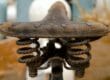 Rusted bike seat with worn leather cover