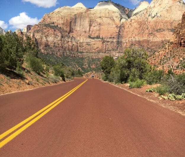 Down hill road in the mountains of Utah with a cyclist descending