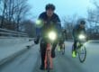 Cyclists riding on a cloudy day with front lights on