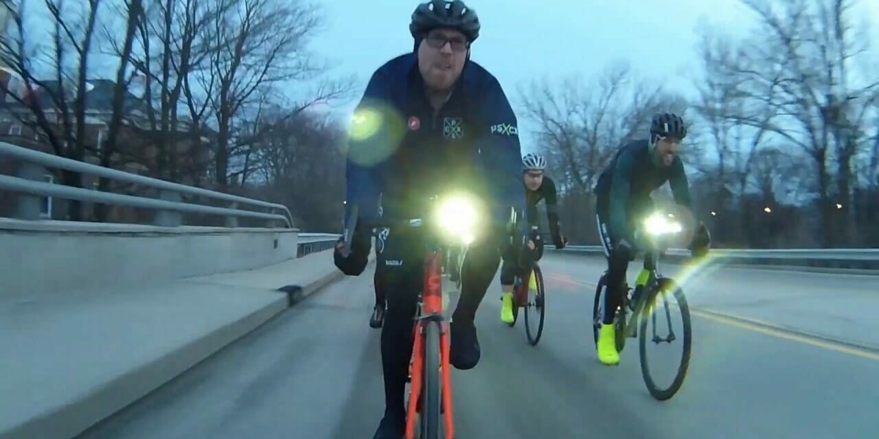 Cyclists riding on a cloudy day with front lights on
