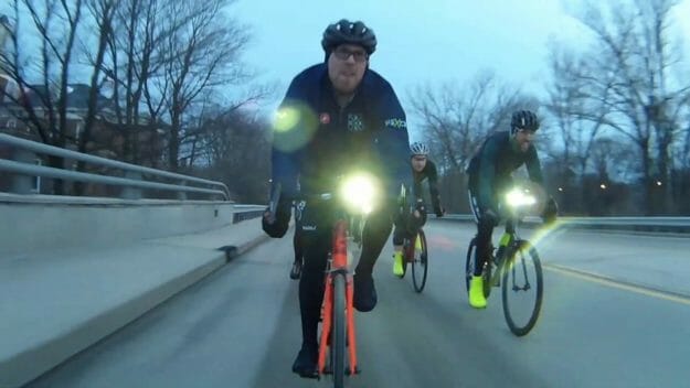 Cyclists riding on a cloudy day with front lights on